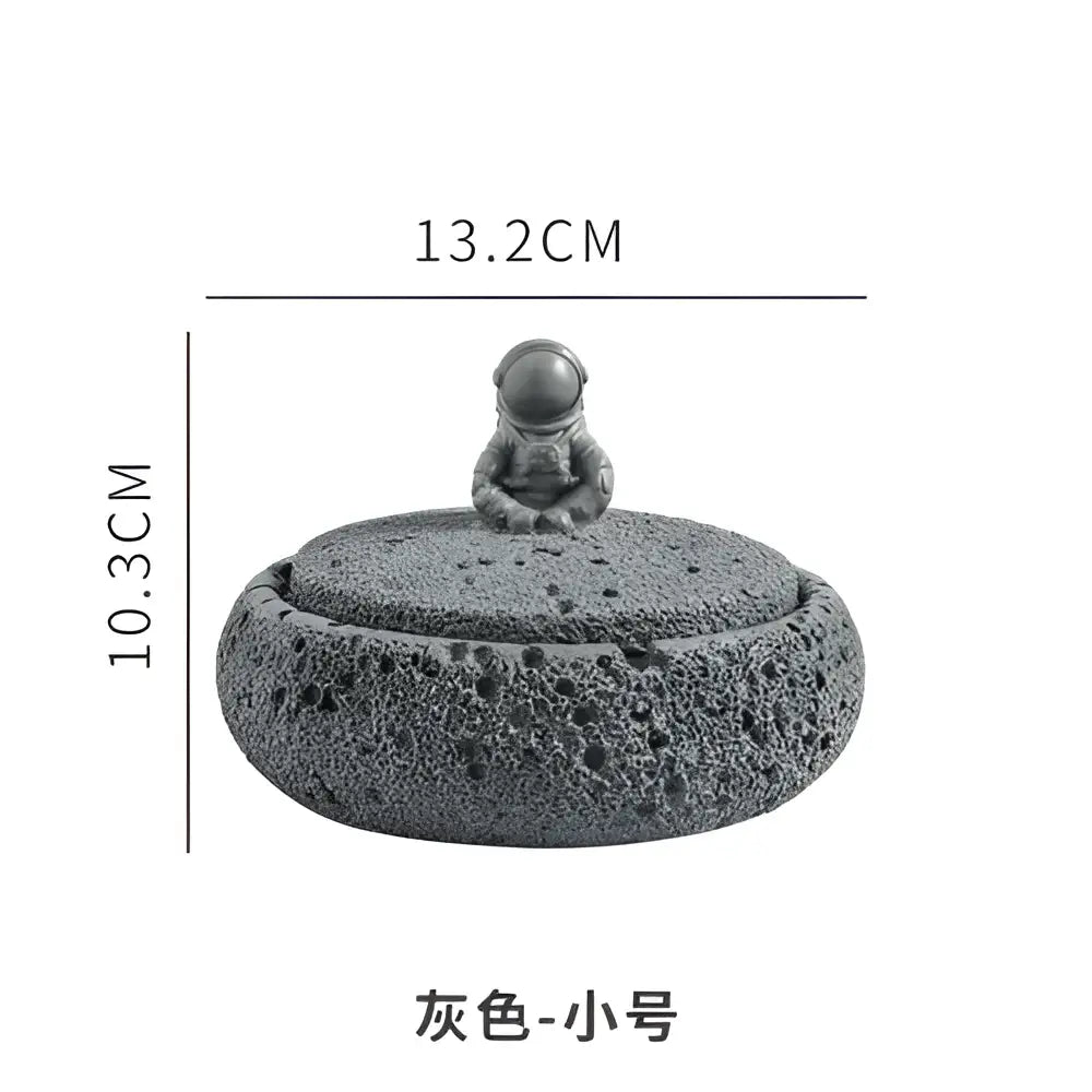 Gray volcanic stone cement astronaut ashtray with textured lid and miniature gray astronaut figurine for living room use