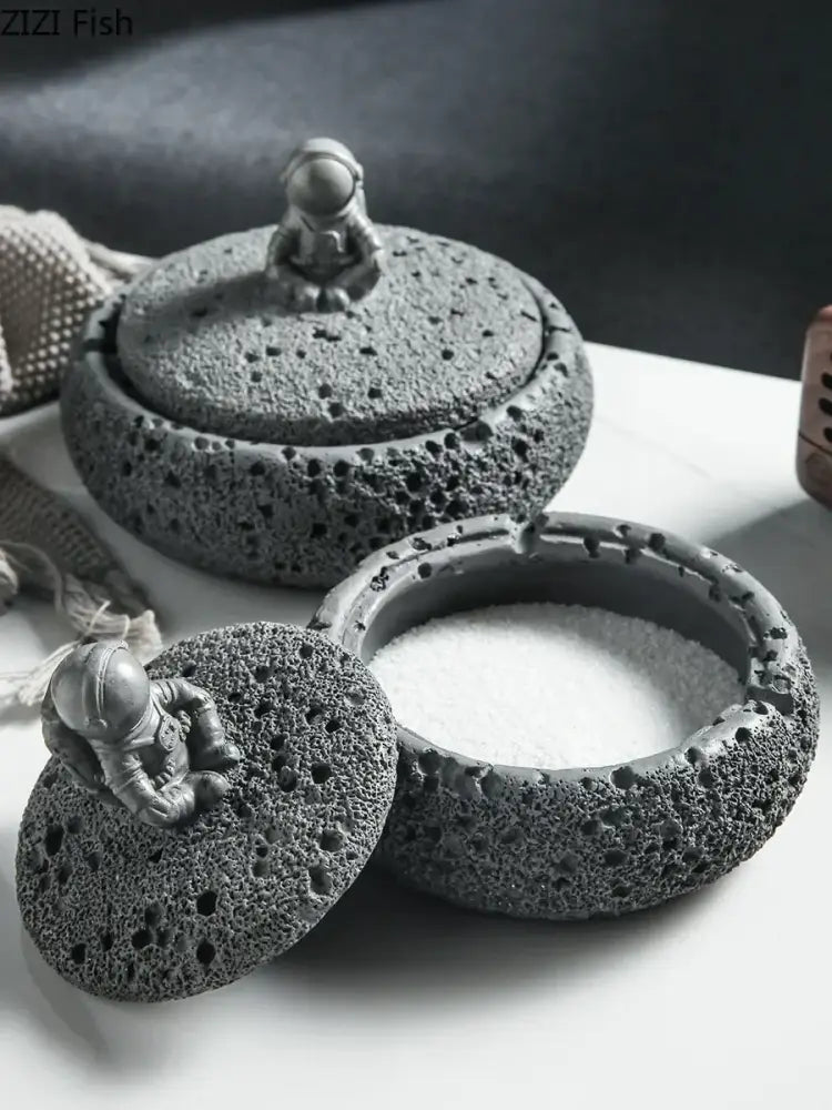Gray volcanic stone ashtray featuring a miniature cement astronaut figurine for living room use as an astronaut ashtray