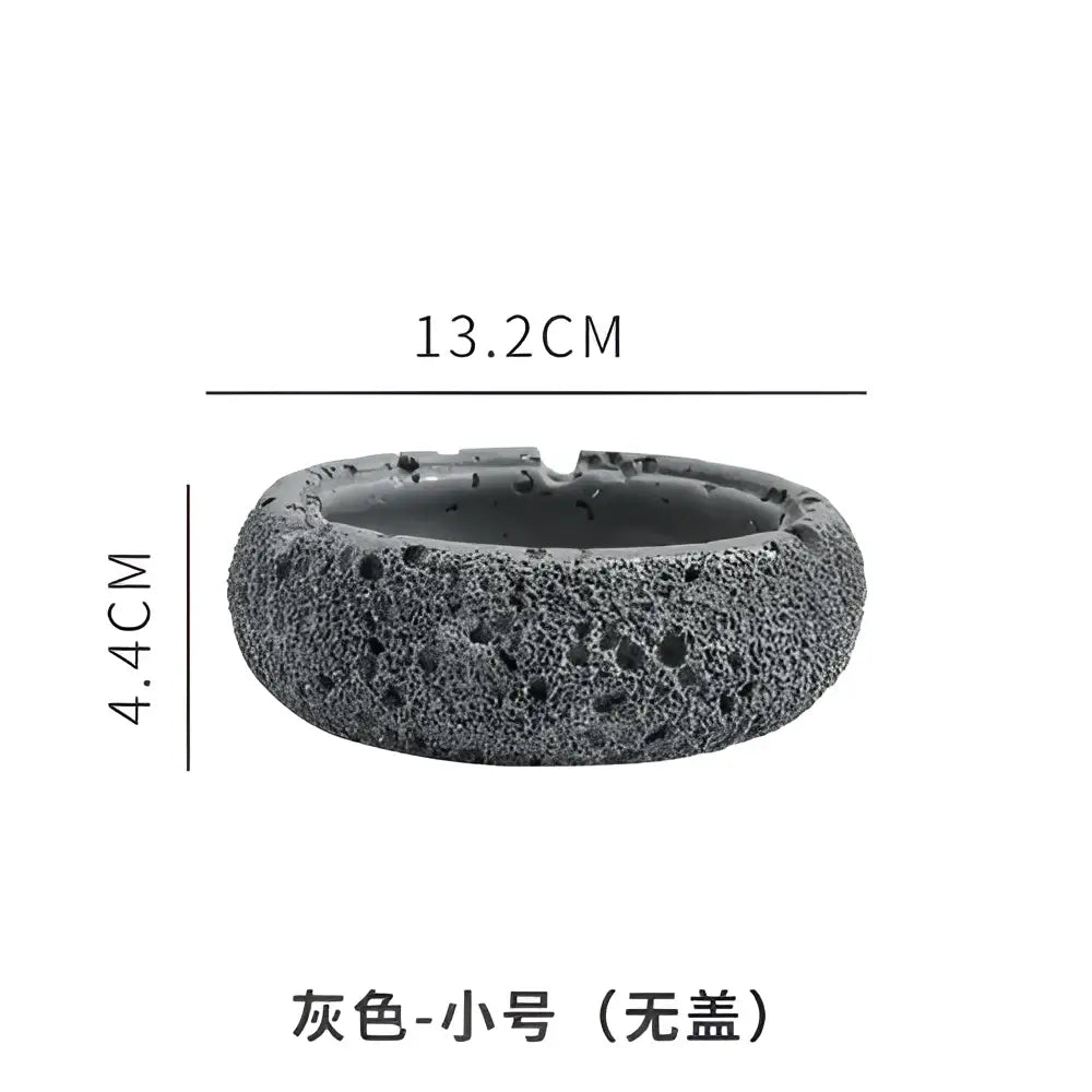 Gray volcanic stone cement astronaut ashtray with textured porous surface and rounded shape for living room use