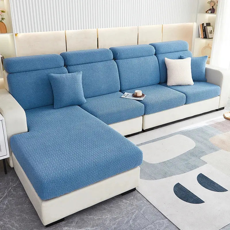 Blue textured decorbites jacquard velvet sofa cover with herringbone pattern snugly fitted over white sectional couch