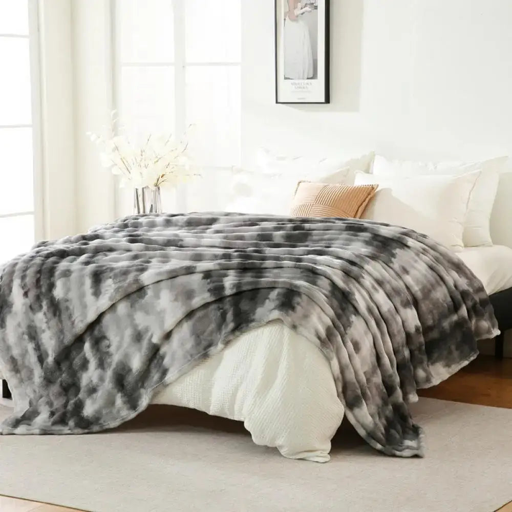A gray and white tie-dye fuzzy faux fur blanket with a soft plush texture ideal for bedroom decorbites fuzzy faux throw