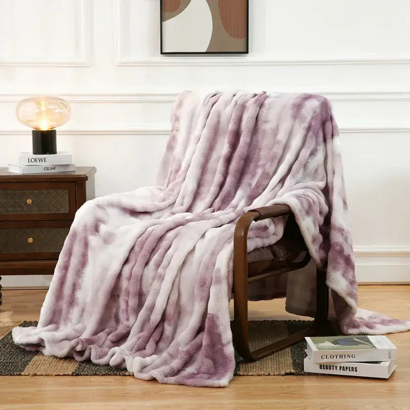 A lavender and white tie-dye fuzzy faux fur blanket draped over an armchair for cozy decorbites fuzzy faux comfort