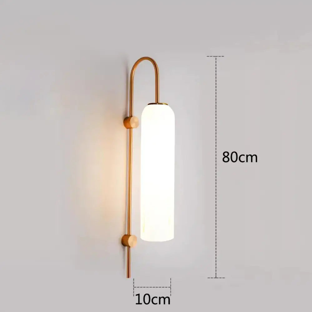 A sleek wall-mounted pendant light with brushed brass frame and frosted glass diffuser for green glass nordic style