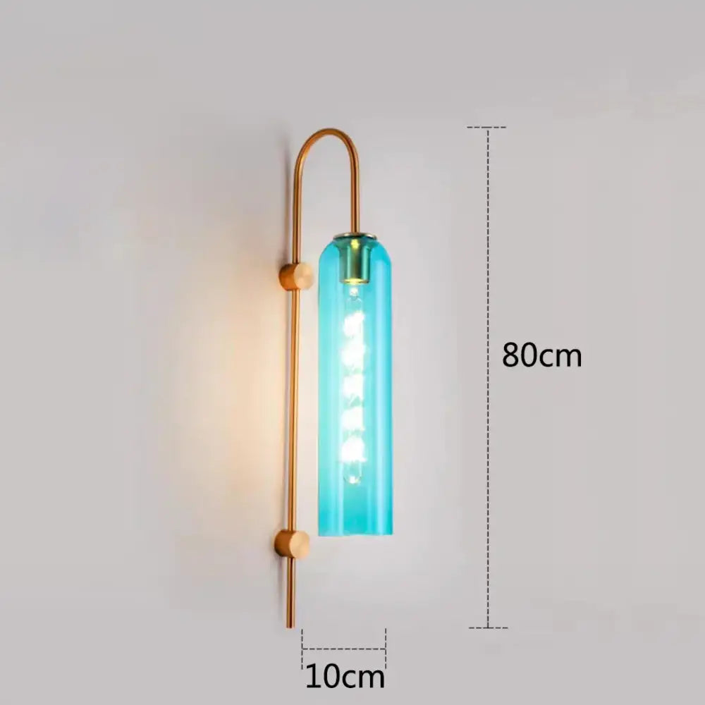 A sleek turquoise glass nordic pendant light with brass metal frame and curved arm for living room lighting