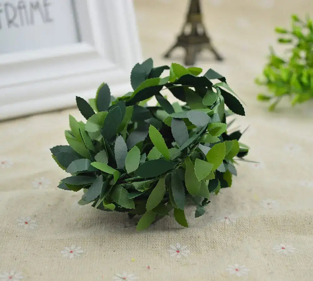 A green leaf vine wreath made of layered textured plastic leaves in varying shades for living room decor