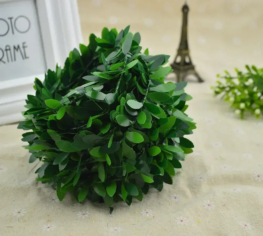 A lush spherical green artificial boxwood topiary with dense glossy leaves for green leaf vine wreath decor