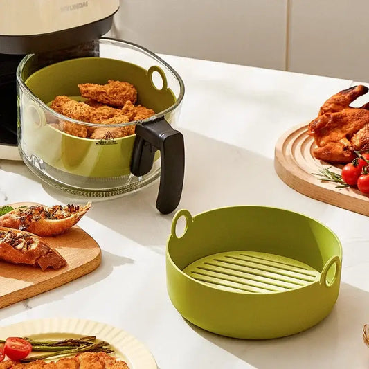 Green and black silicone air fryer pot with ridged interior baking tray and black handle for kitchen use