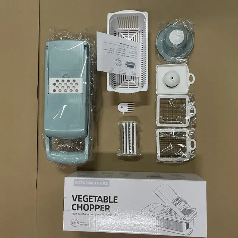 Light blue plastic vegetable slicer cutter with interchangeable metal grating attachments and basket for kitchen use