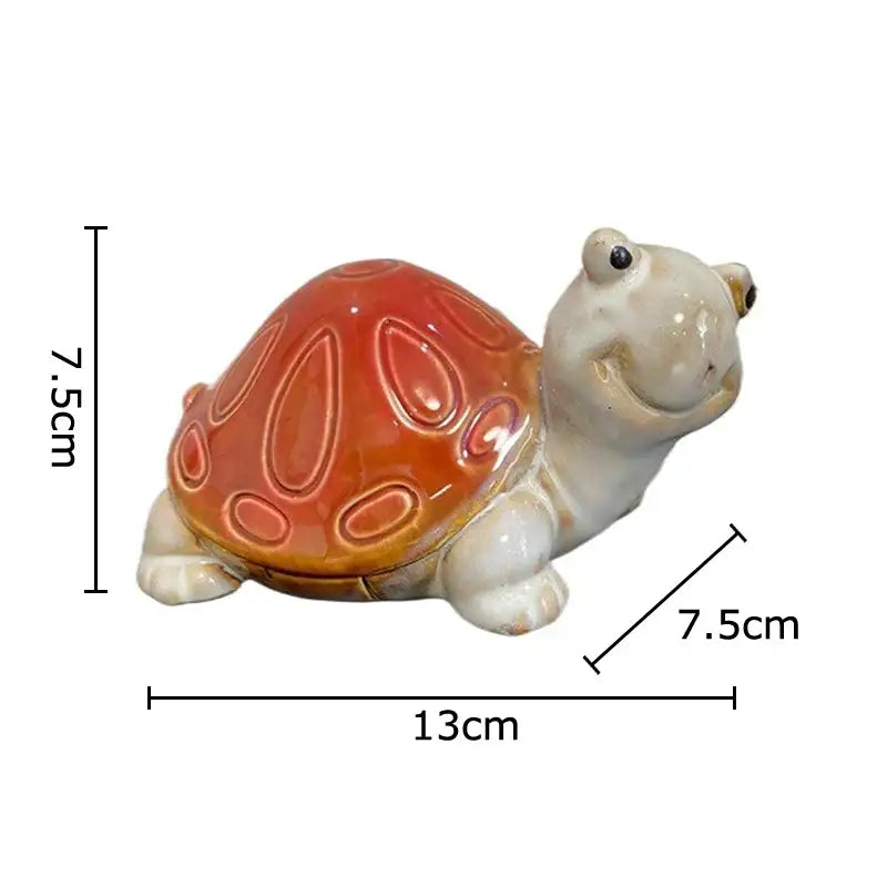 A cute turtle statue ceramic figurine with a glossy orange shell and cream body for living room decor tray