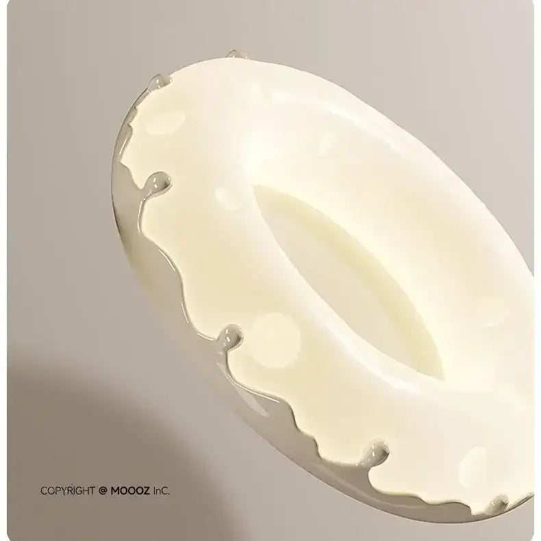 Cream-colored ceramic ashtray with glossy finish and dripping paint effect paired with green and white doughnut ceiling light decorbites ceiling light
