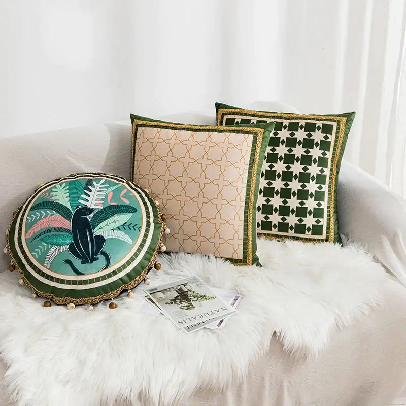 Circular cushion cover with geometric tufted embroidery featuring a black cat and tropical foliage on teal decorbites fabric