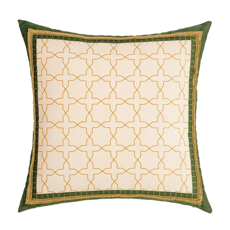 Square cushion cover with cream fabric, gold geometric tufted embroidery, and green border with golden braided trim from decorbites