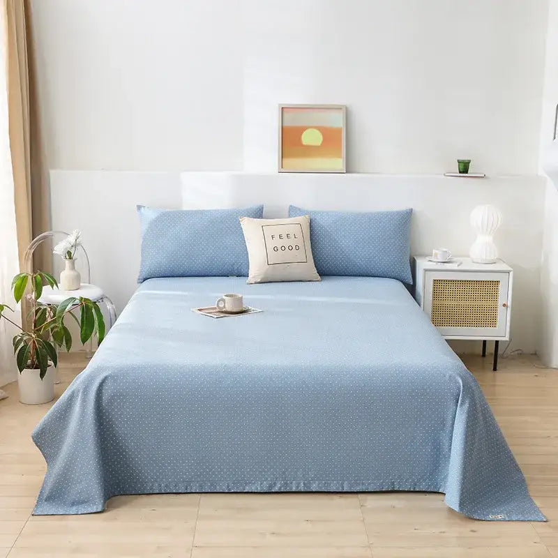 Light blue bedsheet with subtle dotted pattern draped on mattress complementing green and white panda cartoon printed cotton bedspread decorbites cartoon printed design