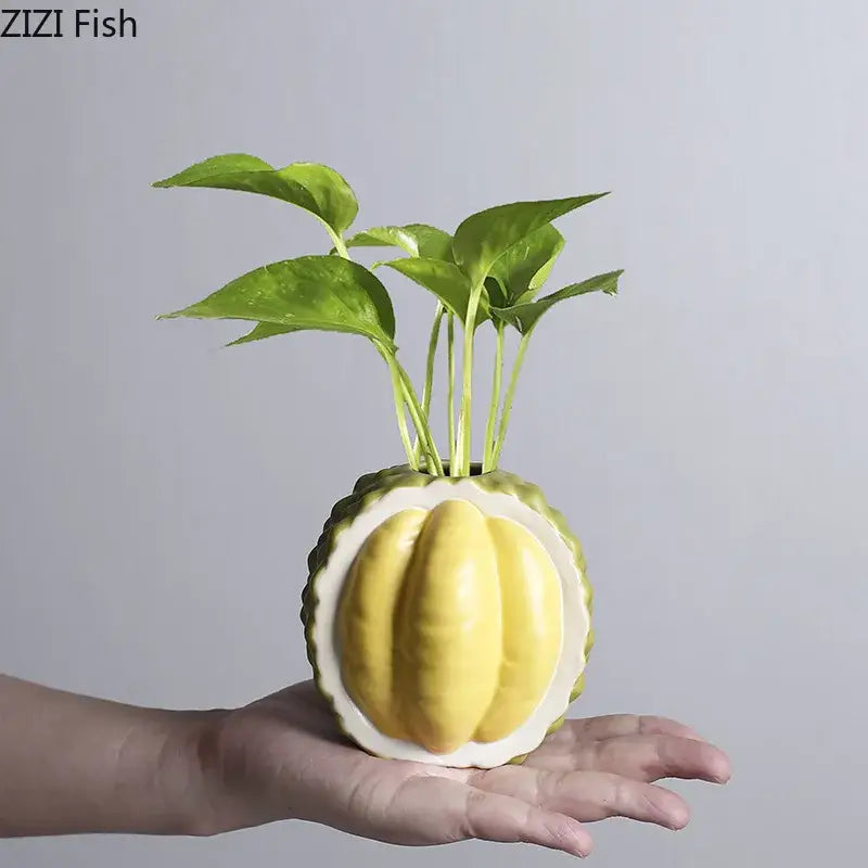 Green and yellow durian ceramic vase shaped like a pumpkin holding vibrant green leaves for living room decor