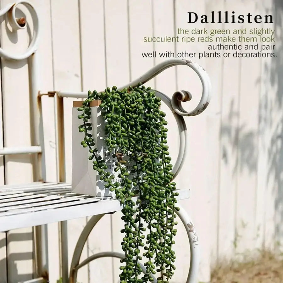Dark green and ripening red artificial fern vine cascading from a white ceramic pot for living room decor