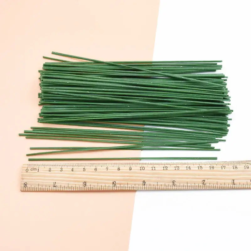 Green artificial flowers iron wire roses stems neatly arranged with wooden ruler for scale ideal for wedding decorbites decor