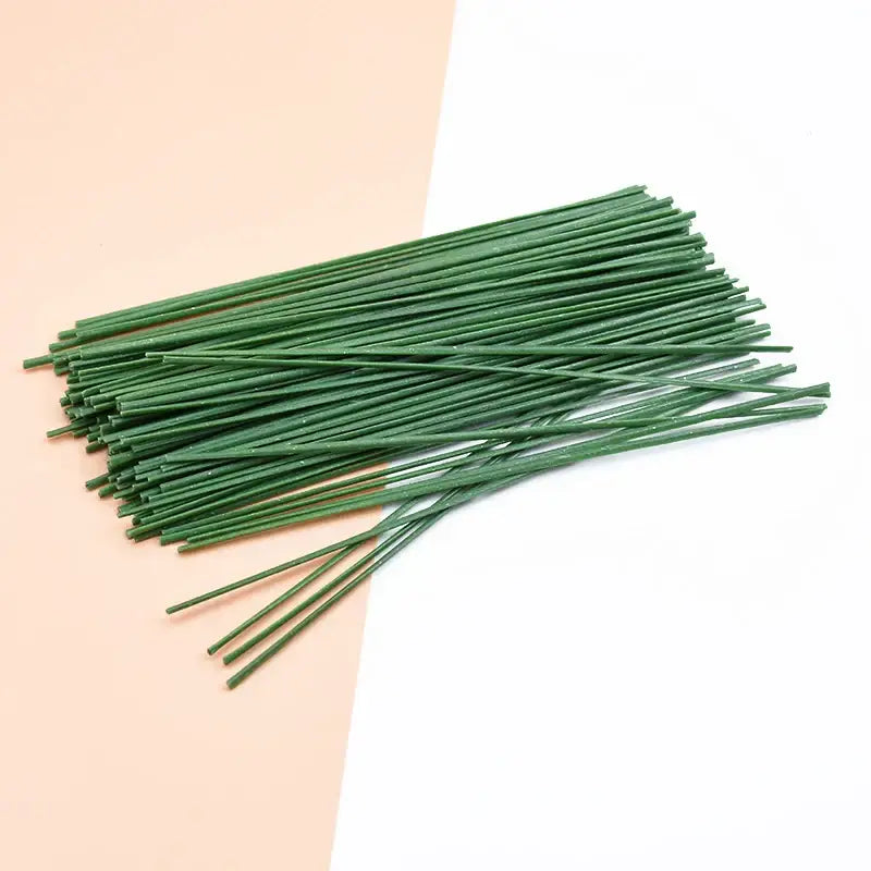 Green artificial flowers iron wire roses stems neatly arranged on two toned background for wedding decor by decorbites iron wire
