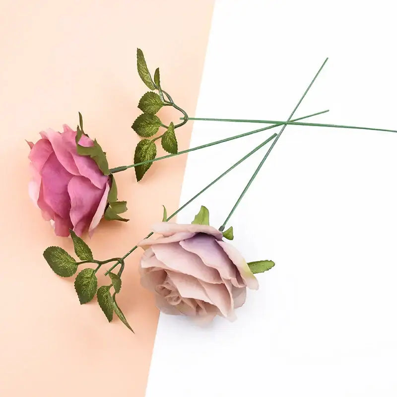 Two artificial flowers with soft pink and mauve petals on green iron wire roses stems for decorbites wedding decor