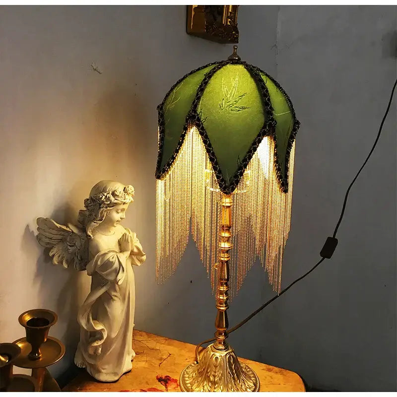 Green bamboo leaf jacquard satin lampshade with black trim and brass fringe on ornate brass base for bedroom use