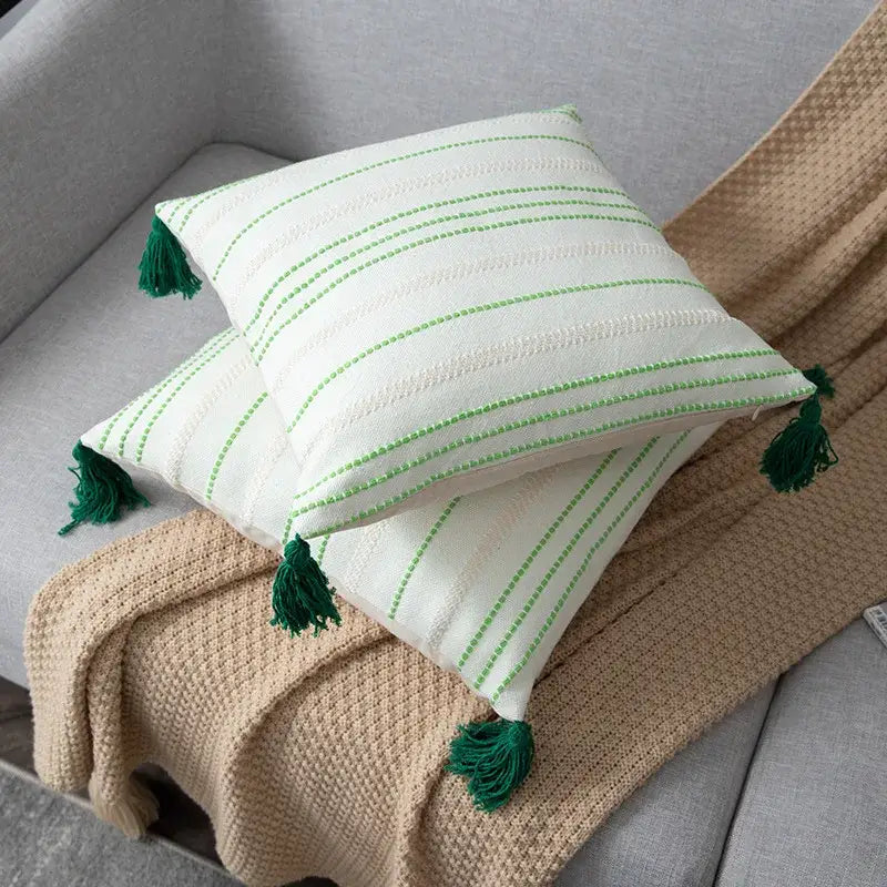 White cushion with green black stripe crochet pattern and matching tassels in living room cushion cover design