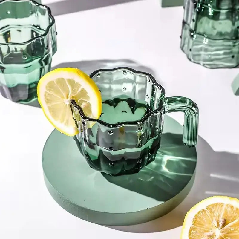 A translucent green cactus glass mug with textured ridges and scalloped rim on a matching circular coaster decorbites cactus glass