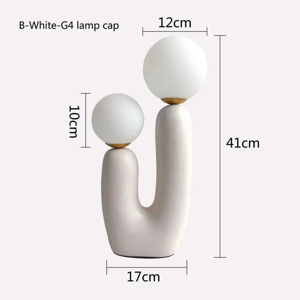White ceramic table lamp with double frosted glass spherical shades and gold-toned metal accents for bedroom use