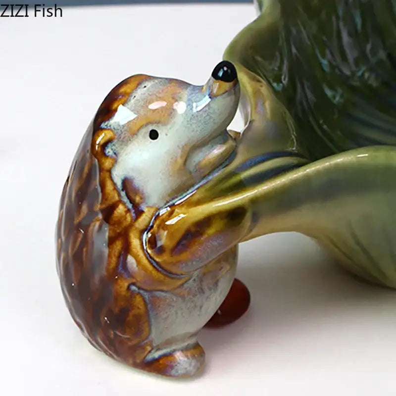 Glossy brown and cream ceramic hedgehog figurine with detailed spines on green decorbites ceramic leaf decor tray