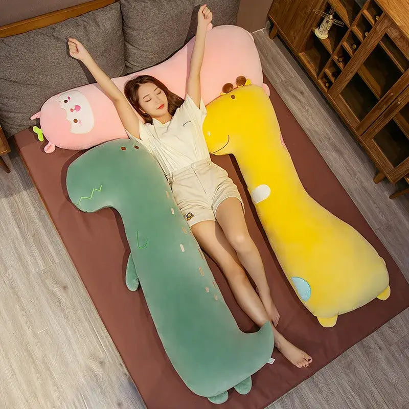 A soft mint green plush cartoon comfort body pillow shaped like a dinosaur with embroidered details and small feet