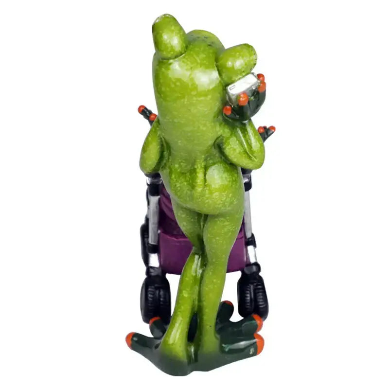 Green frog family statue set resin figurine with orange-tipped toes holding silver device seated on purple stroller decorbites frog family