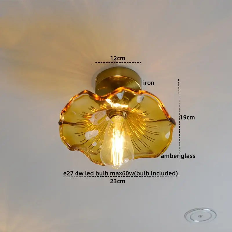 A golden amber glass flower-shaped ceiling lamp with iron base and visible led bulb in copper nordic style