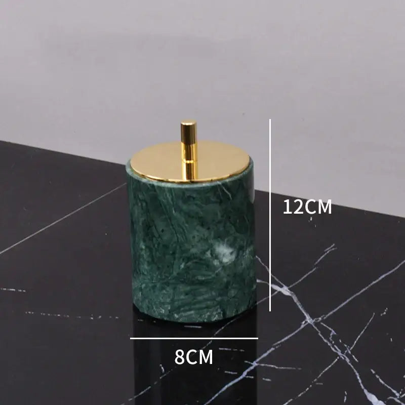 Green marble cylindrical ashtray with gold-toned lid and stem from marble bathroom set with gold accents