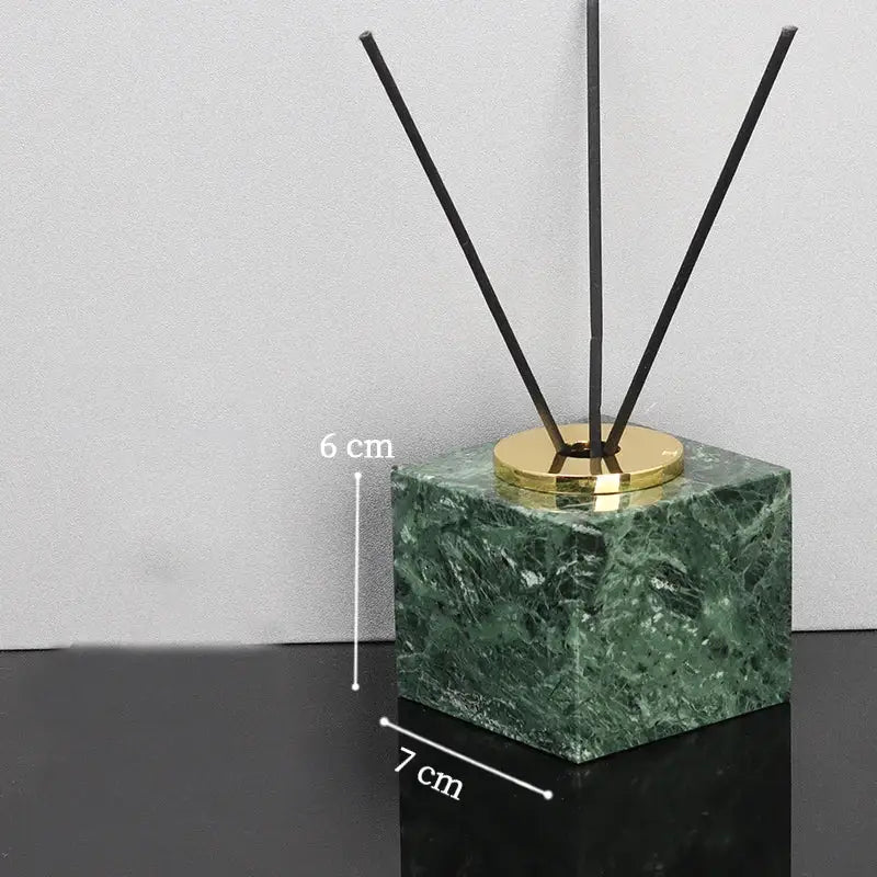 Green marble bathroom set diffuser with gold base and black reeds in a marble bathroom set accessory