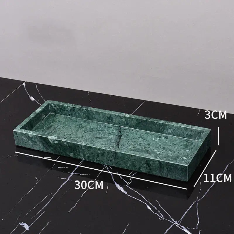 Rectangular green marble tray with polished veined surface and raised edges in a green marble bathroom set