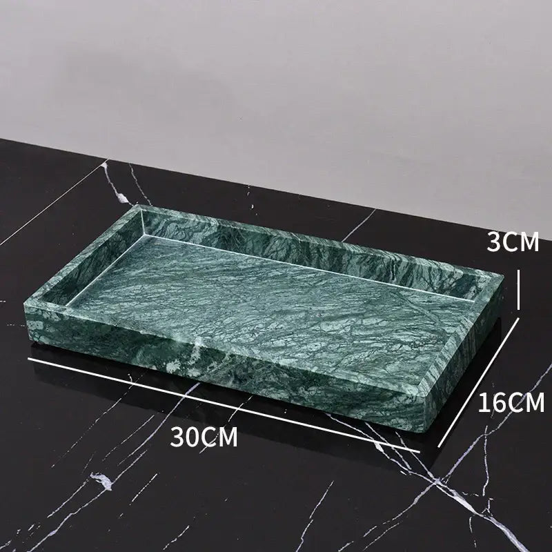 A rectangular green marble bathroom tray with polished veined surface and raised edges in a marble bathroom set