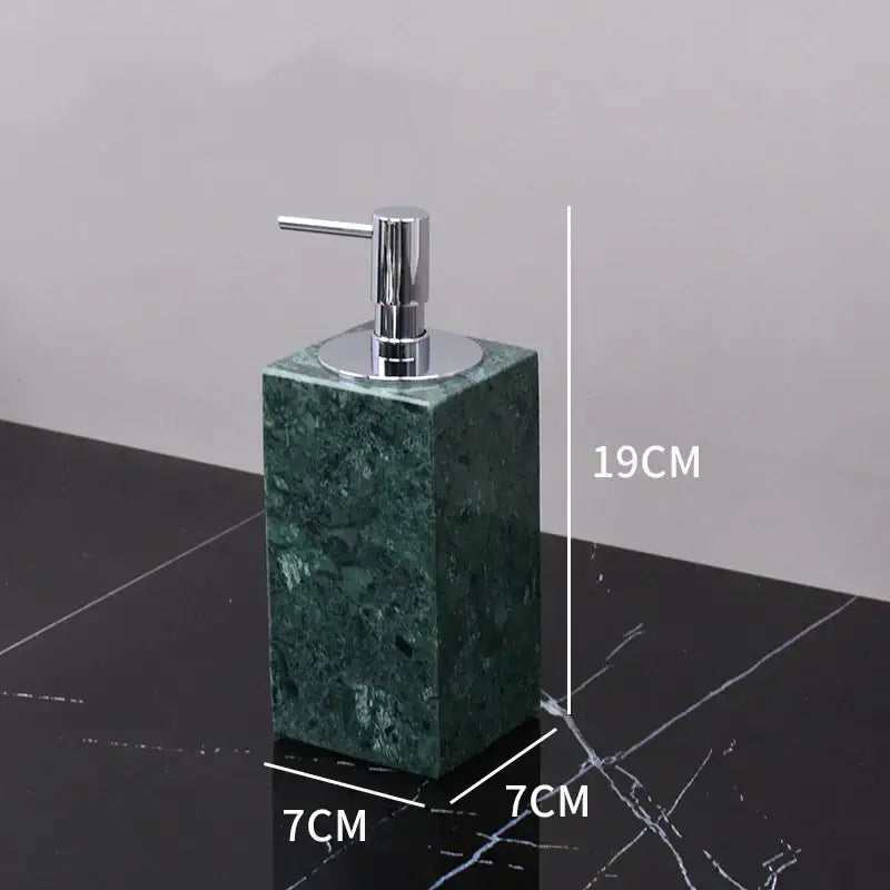 A sleek rectangular green marble soap dispenser with polished chrome pump in a green marble bathroom set