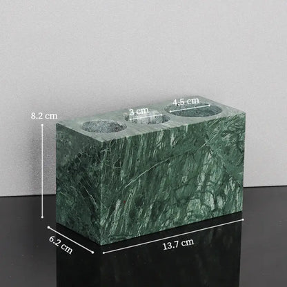 Green marble vase with three circular openings measuring 3 cm 4.5 cm and 8.2 cm from a marble bathroom set with gold accents