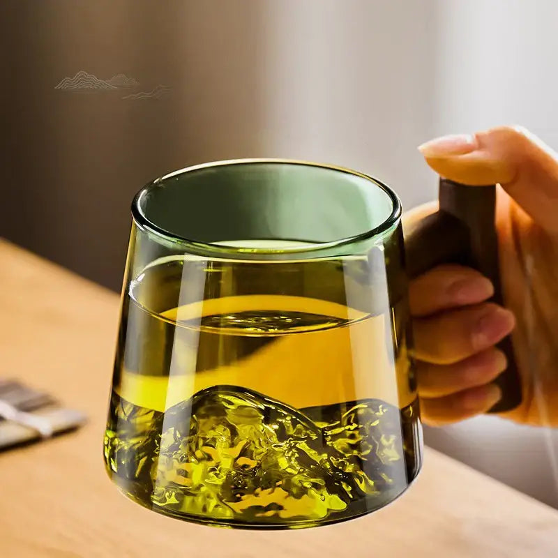 Green mountain glass tea cup set featuring a translucent green glass tea cup with wooden handle and wave base decorbites glass tea