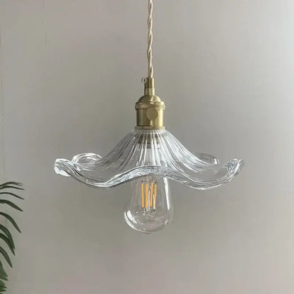 Clear glass pendant light with fluted petal shade and polished copper hardware for dining room illumination
