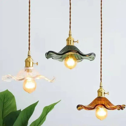 Three vintage-style pendant lights with green and amber glass shades and polished copper fixtures for dining room use