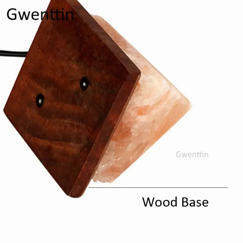 A gwenttin crystal usb salt night light with warm pinkish-orange translucent body on dark wooden base for decorbites decor