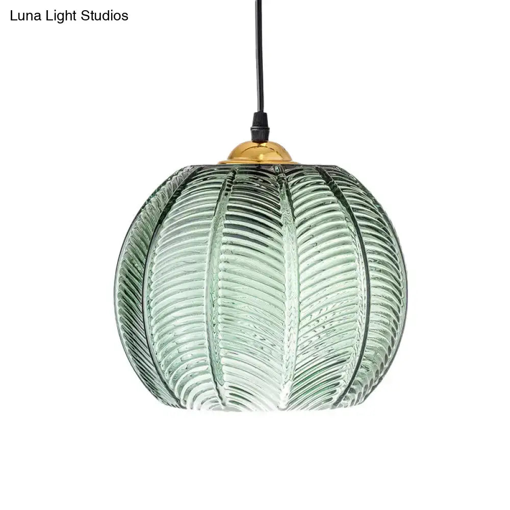 Green ribbed glass pumpkin pendant lamp with translucent textured leaf pattern and brass gold fixture for dining room