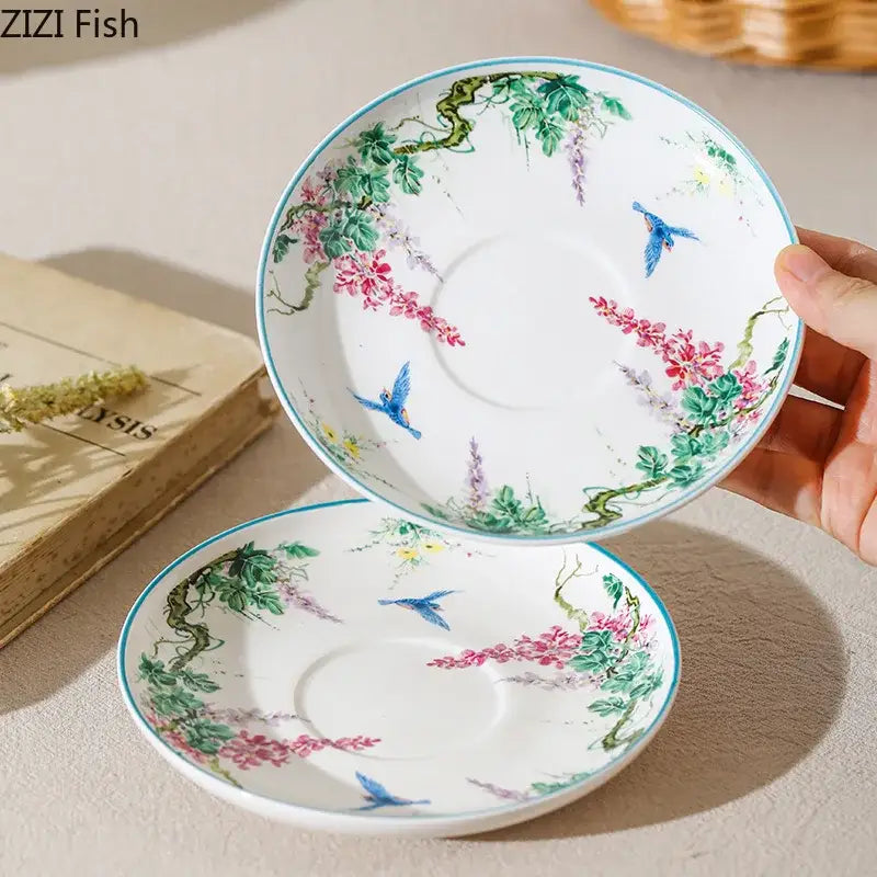 A delicate white green willow porcelain saucer with pink wisteria, green vines, and blue birds for willow porcelain tea sets