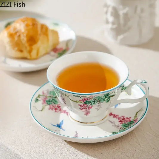 A delicate white green willow porcelain tea cup and saucer set with pink wisteria and gold trim for decorbites green willow
