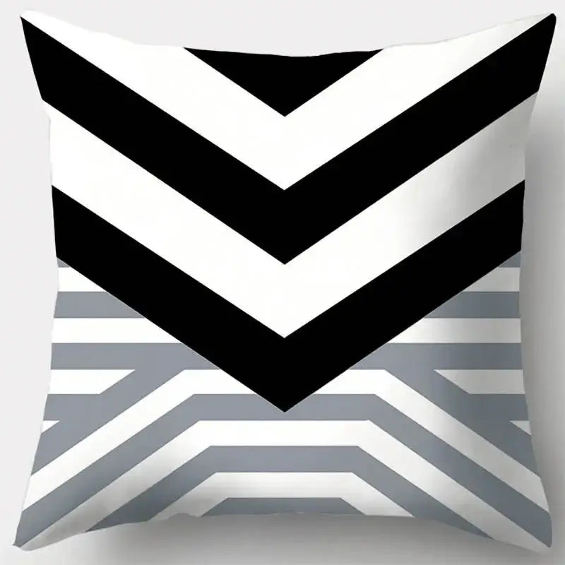 A square pillow case with a bold black and white chevron pattern transitioning into grey geometry stripes for living room decor