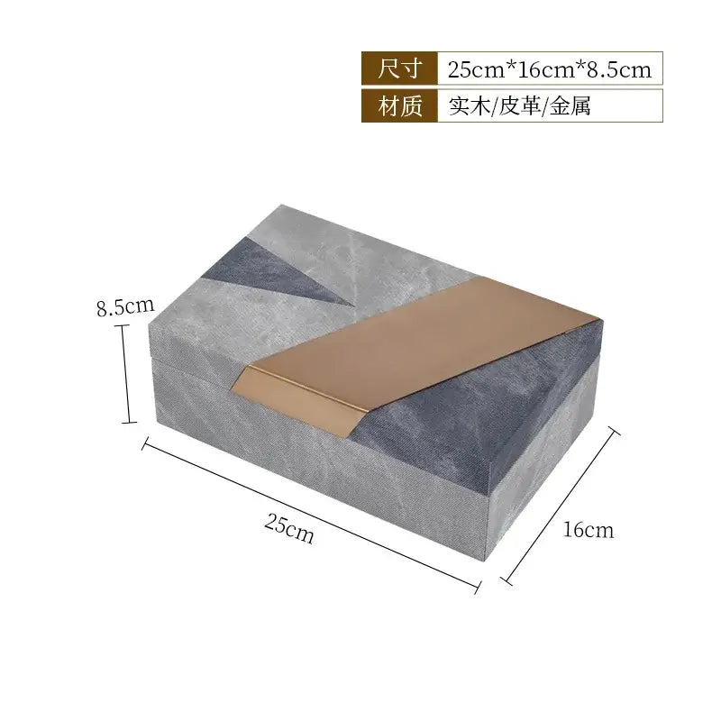 A jewelry container with grey marble pattern leather exterior and gold metallic strip on a rectangular desktop box