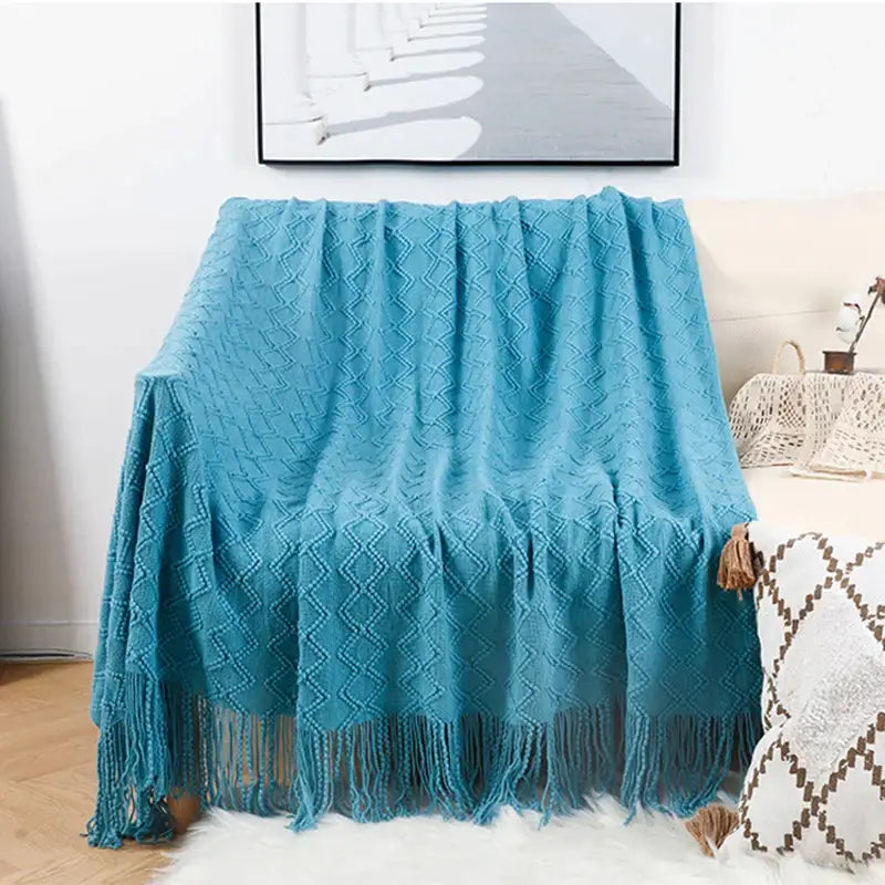 A cozy turquoise knitted throw blanket with diamond pattern and tassels complementing decorbites grey nordic waffle knit decor