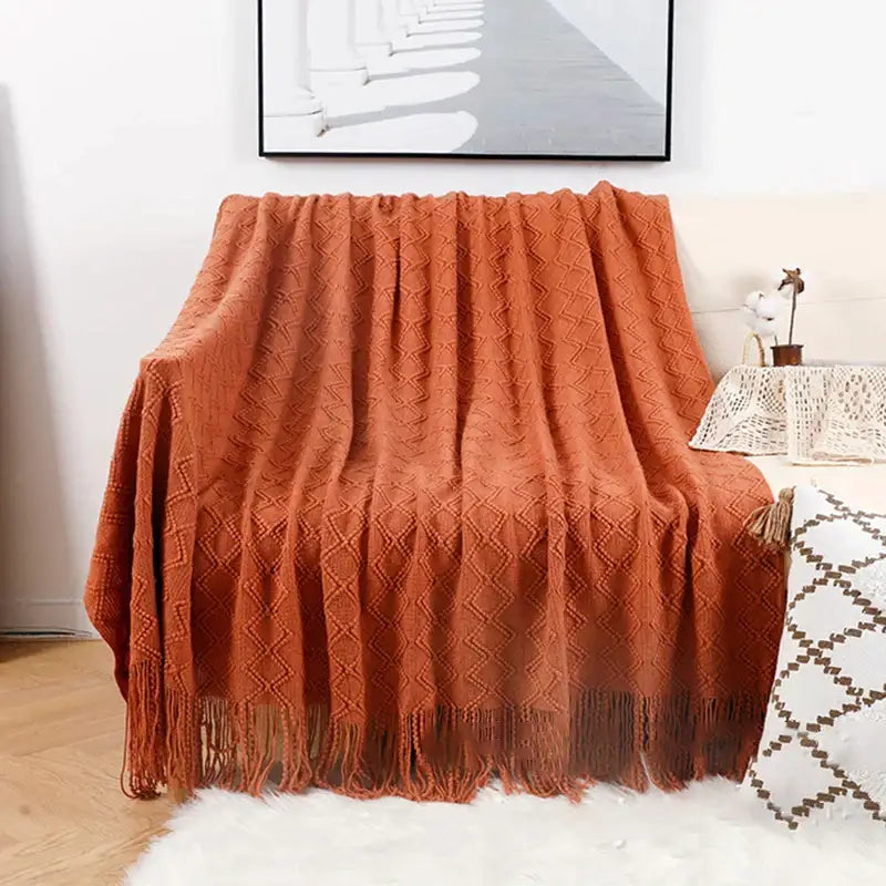 Warm terracotta knitted throw blanket with diamond pattern and tassels paired with decorbites grey nordic waffle knit throw