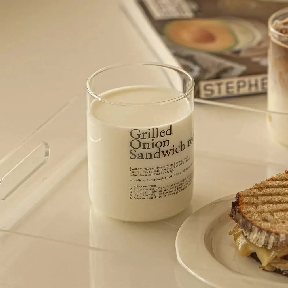 A clear glass coffee cup jar with white wax labeled grilled onion sandwich from decorbites glass coffee cup set