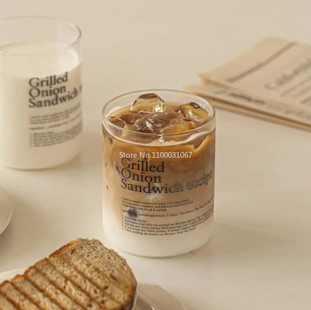 Clear glass coffee cup filled with iced coffee featuring grilled onion sandwich recipe label in decorbites glass coffee set