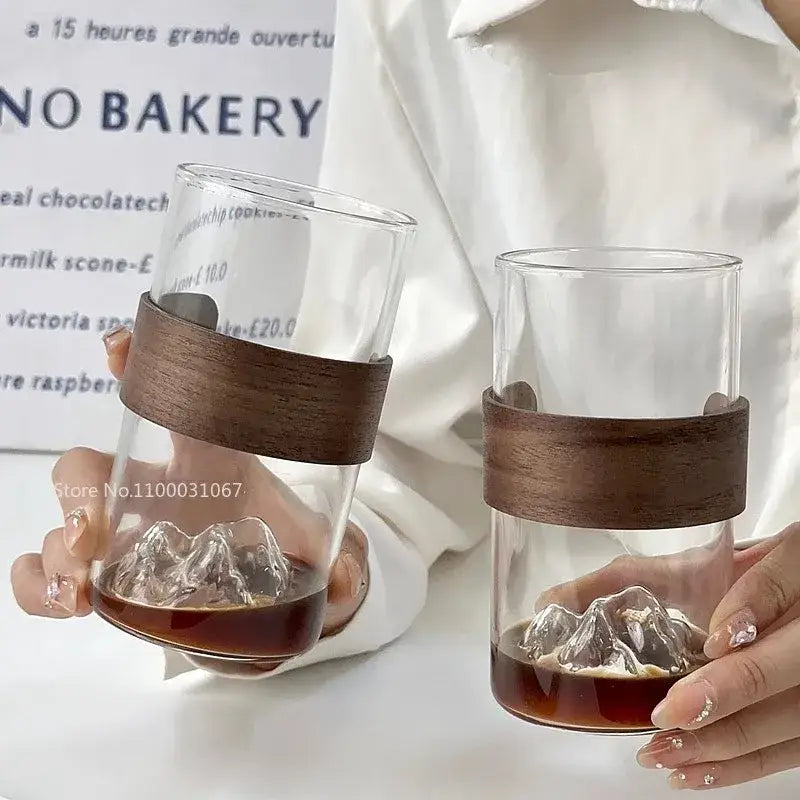 Clear glass guanshan hanging ear coffee cup with dark brown wooden band and mountain-shaped ice cubes for kitchen use